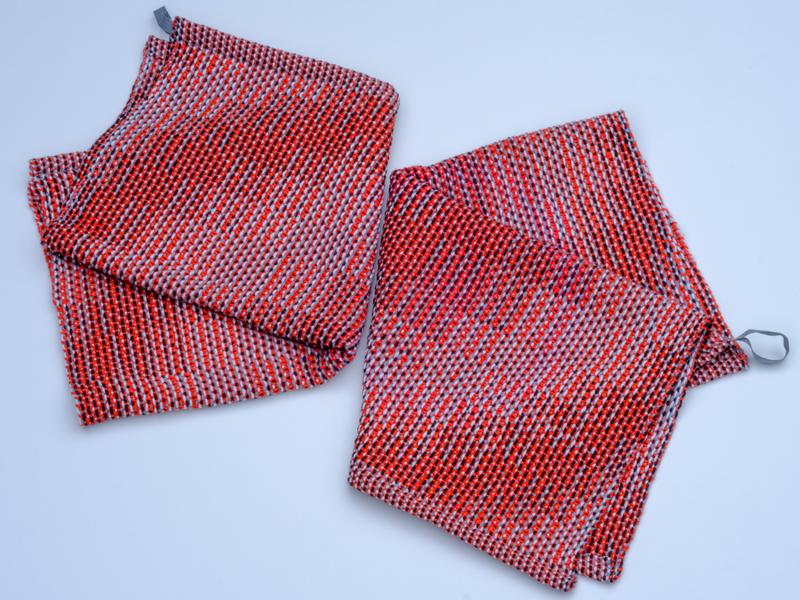 Overview shot of the two red variants of the handwoven towel in cotton yarn using the corris effect