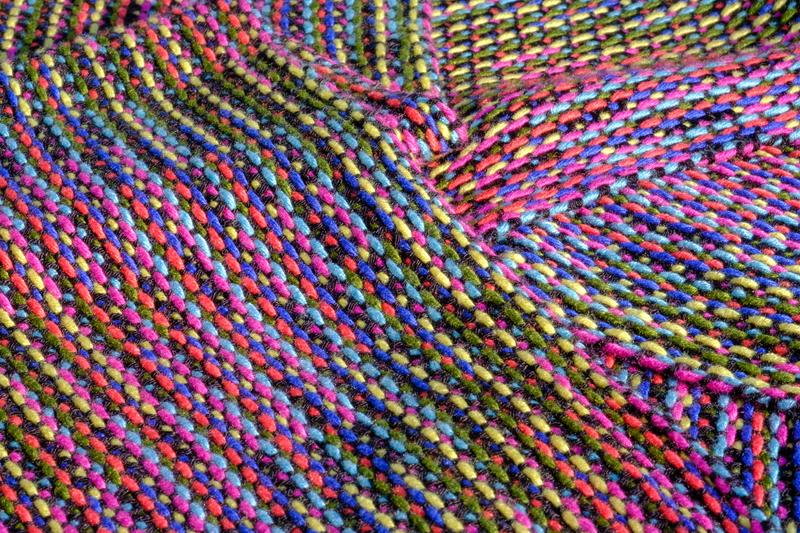 Close-up of a handwoven shawl folded onto itself, showing an elongated diamond in Corris
