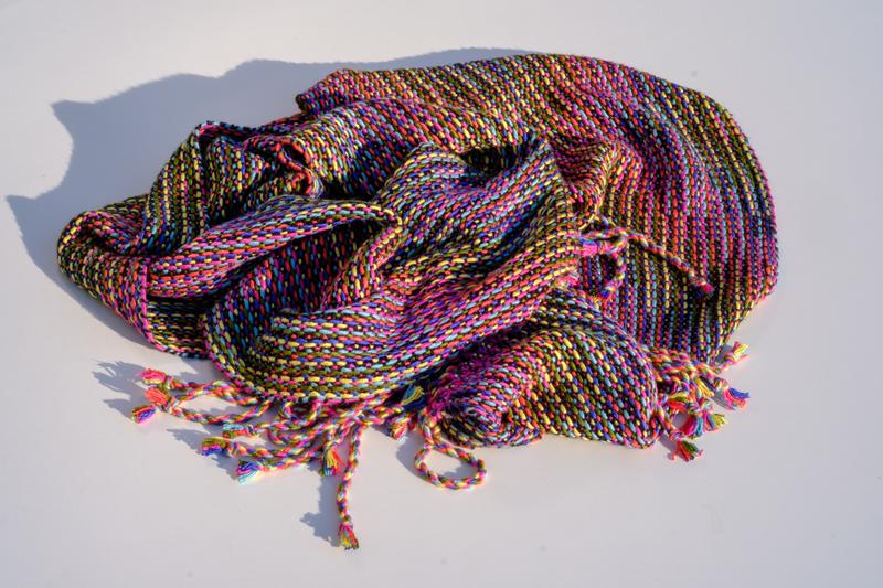 Overview shot of a handwoven shawl in a multi-color Corris pattern wrapped in a bunch