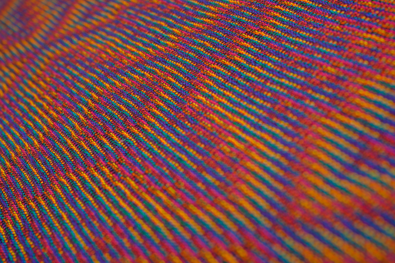 Close-up of a handwoven shawl in rainbow colors at a low angle