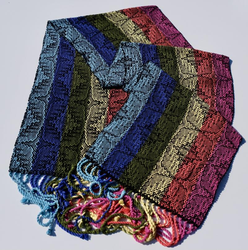 Overview shot of a handwoven shawl in rainbow-colored bamboo yarn using advancing twill
