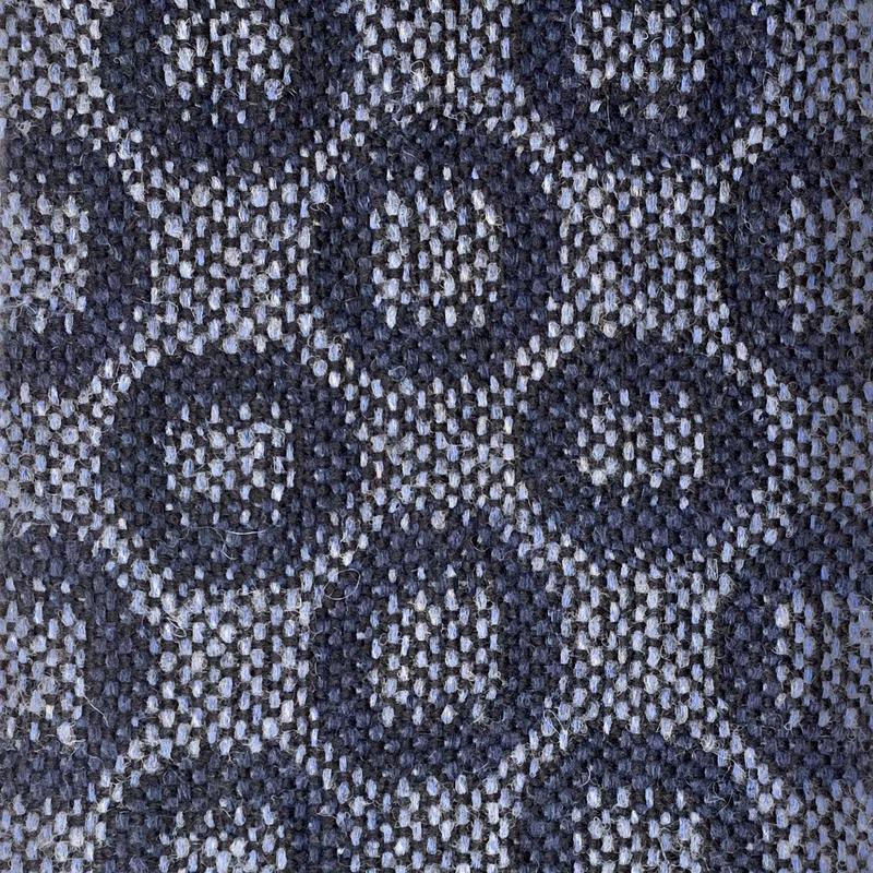 Close-up of turned taquete circles in dark blue on light blue background