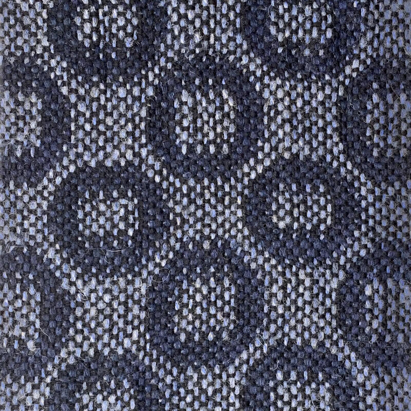 Close-up of turned taquete circles in dark blue on light blue background