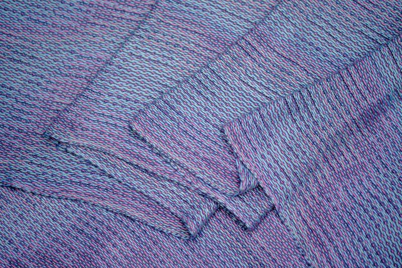 Close-up shot of a handwoven shawl in lyocell yarn using the Corris effect while gently folded into waves
