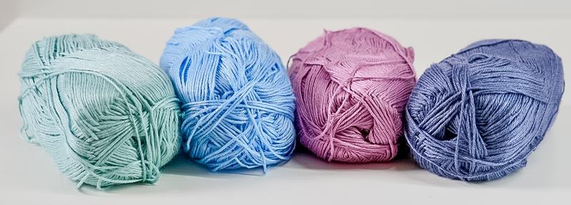 Four balls of lyocell yarn in pastel colors