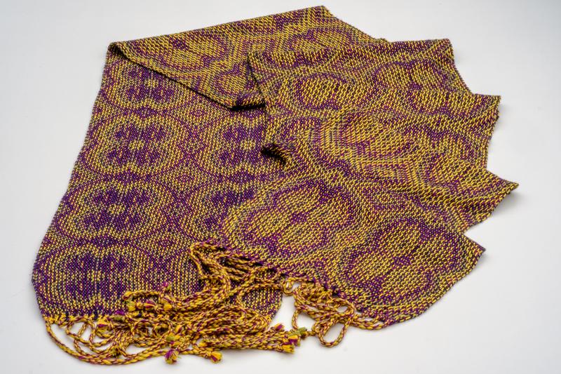 Overview of a handwoven shawl using the corris effect to create symmetric flowers, made in lyocell yarn